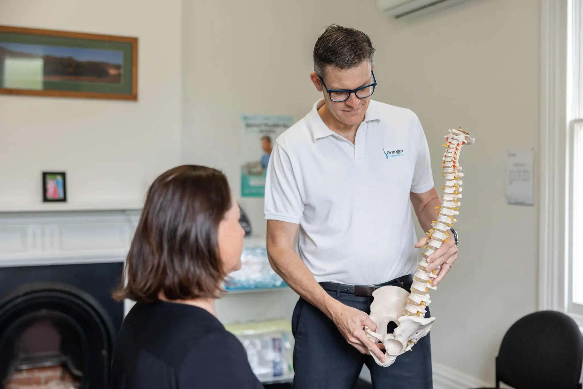 Chiropractor demonstrating spine model to patient